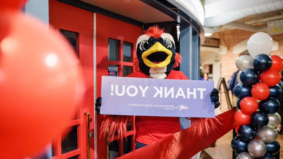 Rowdy holding a Thank You sign in front of Rowdy's Corner at the grand opening in November 2022.